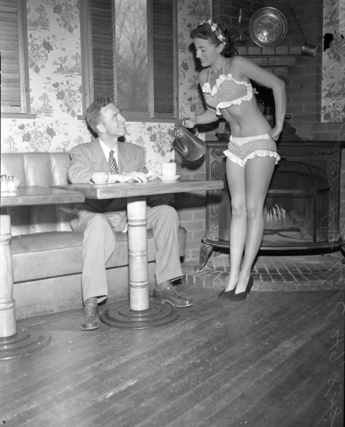 Pat Hall, "Miss 7-Cent Cup of Coffee, 1950," serving William E. Kinman coffee while wearing a bikini, Los Angeles, CA  --1950. 